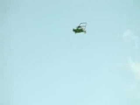 flying green lawnmower in a blue sky